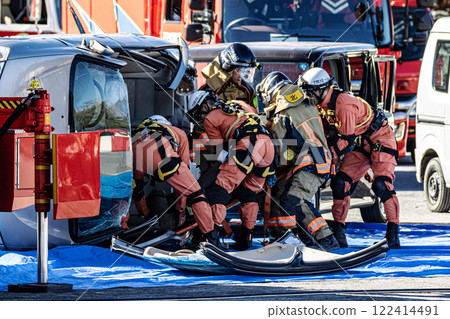 Rescue team members perform rescue training using a hydraulic cutter to cut off the roof of a car that has overturned in an accident during a fire drill at the New Year's ceremony. Rescue team members perform rescue training using a hydraulic cutter to cut off the roof of a car that has overturned in an accident during a fire drill at the New Year's ceremony. 122414491