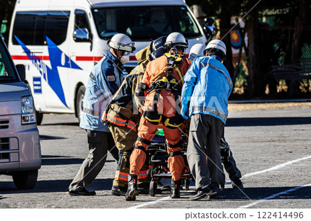 A rescue team member transports an injured person on a stretcher after being rescued by firefighters during a New Year's fire drill. 122414496