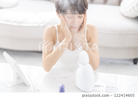 一位中年婦女用蒸臉器進行蒸氣清潔 122414605