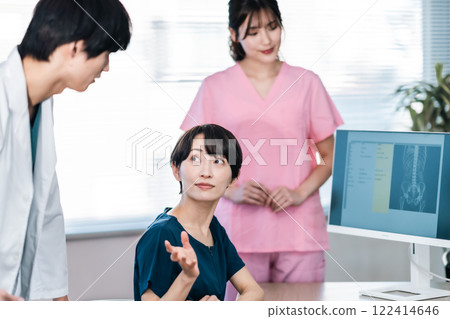 A doctor checking the medical records on the monitor 122414646