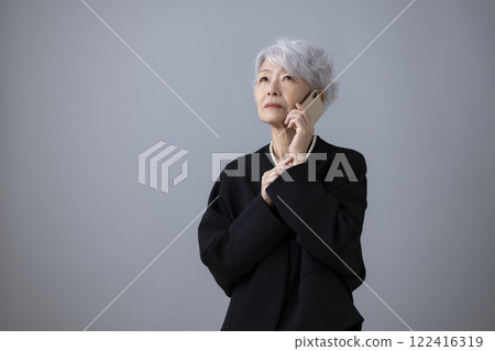 Mourning clothes Senior woman making a phone call on her smartphone 122416319
