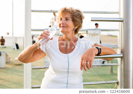 Mature sportswoman in workout station Mature sportswoman in workout station 122416600