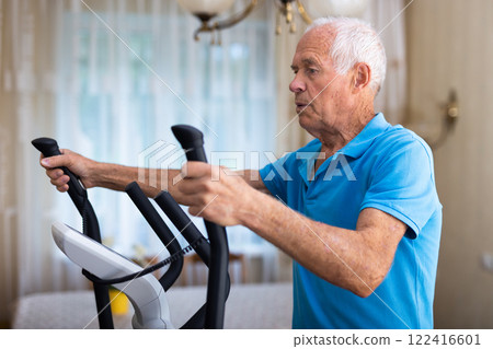 Male is working out on elliptical machine for elder healthy concept Male is working out on elliptical machine for elder healthy concept 122416601