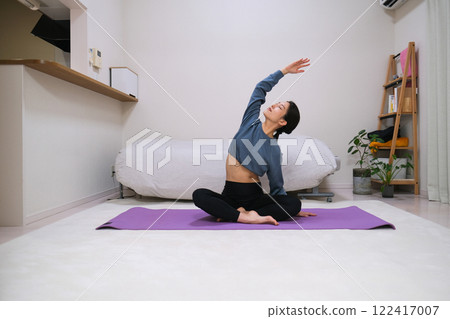 Woman doing yoga in the living room 122417007