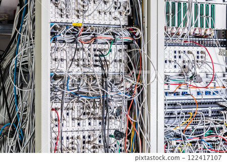 server room rack with tangled network cables creating messy unti 122417107