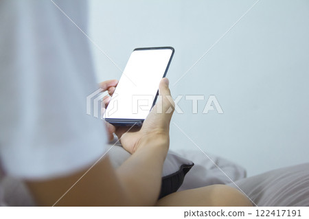 A man checks to browse online shopping on his smartphone  night at home at night. 122417191