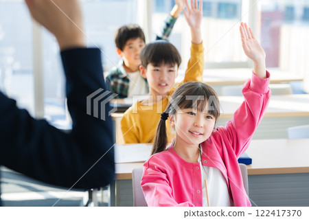 Image of elementary school students raising their hands in the classroom Image of elementary school students raising their hands in the classroom 122417370