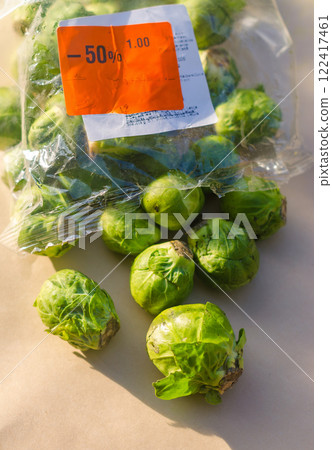 Brussels sprouts spilling from a plastic bag with discount label . High quality photo 122417461