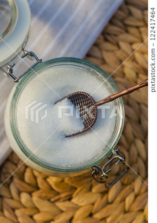 White sugar in a glass jar with a small scoop. High quality photo 122417464