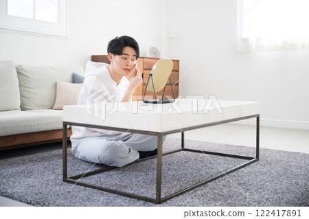 一個年輕人照鏡子並塗抹底座或粉底的美麗和美麗形象的俯視圖 122417891