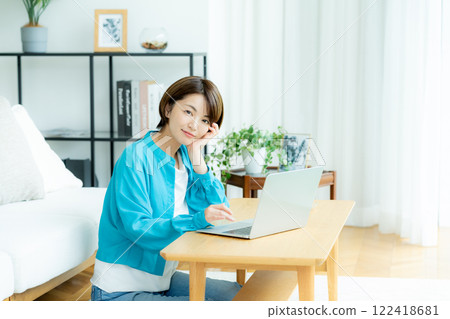 女人在家操作一台筆記本電腦 122418681