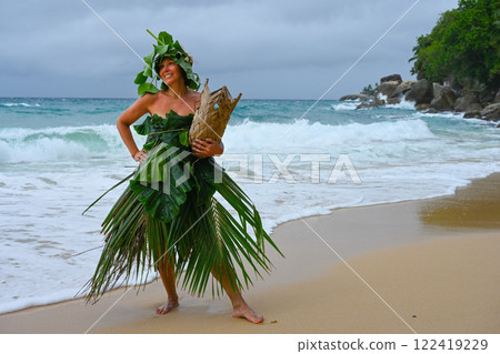 Robinson Crusoe woman dressed in palm branches on the seashore 122419229