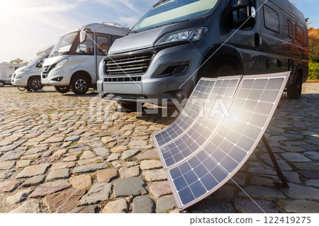 Many modern parked camper vans charge battery generator portable solar panels by clean eco energy, enabling off-grid travel freedom travel on sunny summer day. Innovative sustainability technology Many modern parked camper vans charge battery generator portable solar panels by clean eco energy, enabling off-grid travel freedom travel on sunny summer day. Innovative sustainability technology 122419275