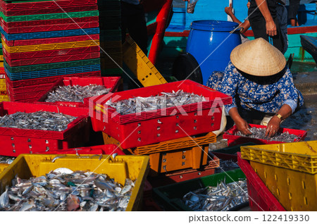 Vietnamese women in conical hats prepare fish for sale at the local market. Vietnam, Nha Trang 122419330