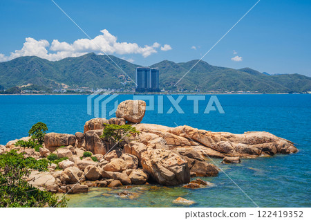 Large rocks on the background of the beach, mountains and high-rise buildings in Nha Trang. Hon Chong cape rock garden Large rocks on the background of the beach, mountains and high-rise buildings in Nha Trang. Hon Chong cape rock garden 122419352