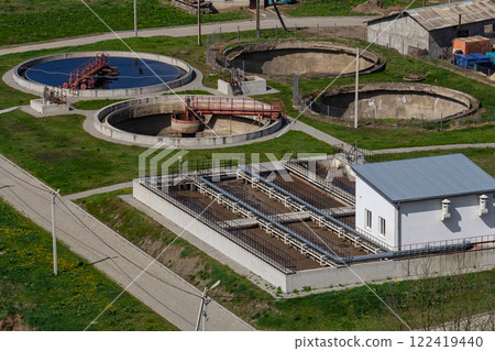 Water treatment facility in operation with multiple tanks and pathways in a green environment 122419440