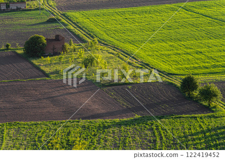 Lush green fields and farmland with a rustic barn in the countryside during daylight Lush green fields and farmland with a rustic barn in the countryside during daylight 122419452
