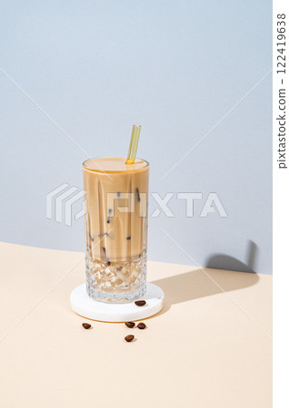 Cold latte coffee in a tall glass with lactose-free milk on a marble stand on a blue background 122419638
