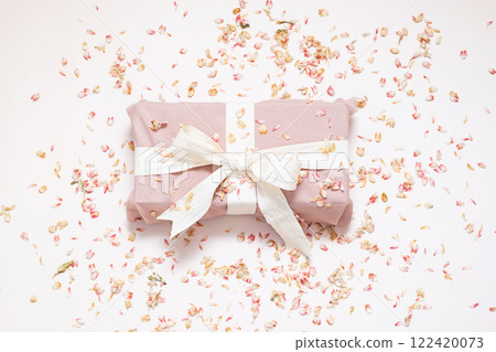 Sustainable wrapped present and dried petals confetti. Zero waste holiday background. Sustainable wrapped present and dried petals confetti. Zero waste holiday background. 122420073