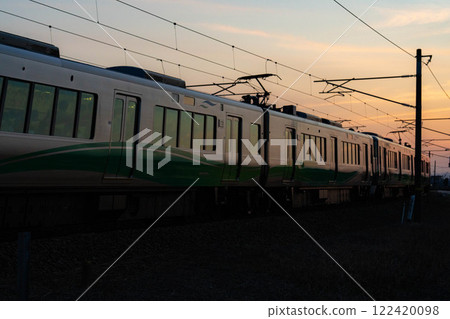 [Sunset material] Scenery of the Ainokaze Toyama Railway at dusk [Toyama Prefecture] 122420098