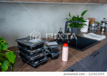 Black boxes with healthy diet plan for weight loss, delivery of daily ready meal menu. Food ordered with mobile phone app. Balanced portion with dish. Pre-cooking. 122421055