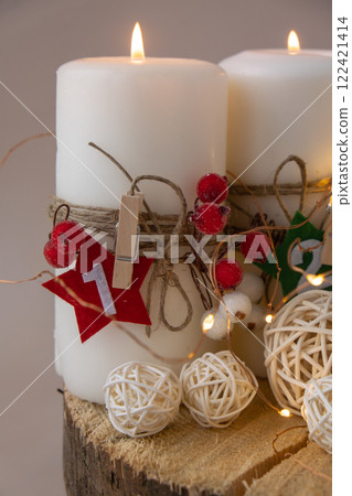 Traditional Burning Christmas Wax Candles with numbers counting down for Christmas New year and Christmas preparation. Four-week advent candles on table. Handmade eco-friendly decor. Sustainable 122421414