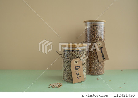 Raw buckwheat porridge and green lentil in sustainable natural packaging. Refillable systems. Gluten free cereals. Health gut benefits. Concept of alternative whole spelt grain ingredient. Vegetarian Raw buckwheat porridge and green lentil in sustainable natural packaging. Refillable systems. Gluten free cereals. Health gut benefits. Concept of alternative whole spelt grain ingredient. Vegetarian 122421450