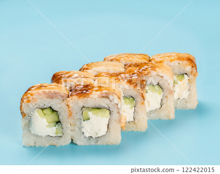 Studio photography of Philadelphia Roll of velvety cream cheese and cucumber wrapped in perfect seasoned sushi rice and fresh unagi smoked eel. Isolated on solid light blue background 122422015