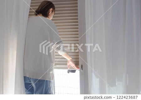 一位女士打開和關閉百葉窗的圖片 一位女士打開和關閉百葉窗的圖片 122423687