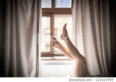 Young woman sitting on a chair by the window in the morning. 122423769
