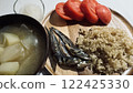 A plate of brown rice and grilled fish with miso soup and tomatoes for a nutritious meal 122425330