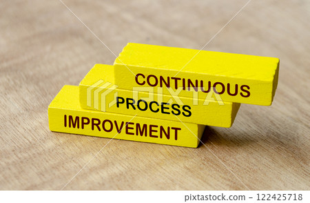 Continuous process improvement text on yellow wooden blocks. Business strategy and improvement concept 122425718