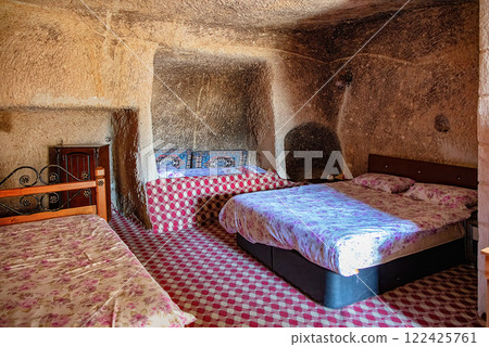 Unique cave accommodation showcasing rustic charm and comfortable beds in a cozy setting 122425761