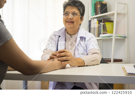 General practitioner taking notes when talking to female patient in hospital. General practitioner taking notes when talking to female patient in hospital. 122425910