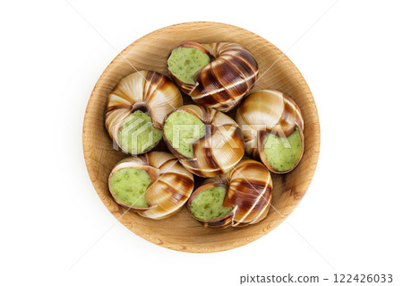 escargot snail filled with garlic and parsley butter in wooden bowl isolated on white background. Top view. Flat lay escargot snail filled with garlic and parsley butter in wooden bowl isolated on white background. Top view. Flat lay 122426033