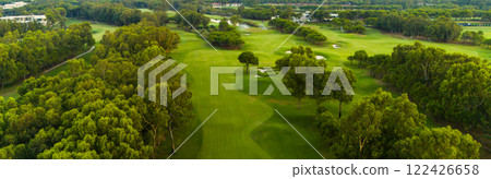 A panoramic view of a lush golf course surrounded by greenery and trees A panoramic view of a lush golf course surrounded by greenery and trees 122426658