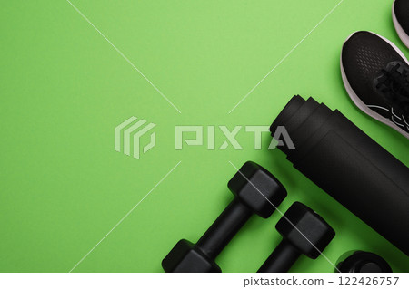 Black workout equipment for training at home on bright green background. Fitness, sport items, healthy lifestyle concept. Copyspace Black workout equipment for training at home on bright green background. Fitness, sport items, healthy lifestyle concept. Copyspace 122426757