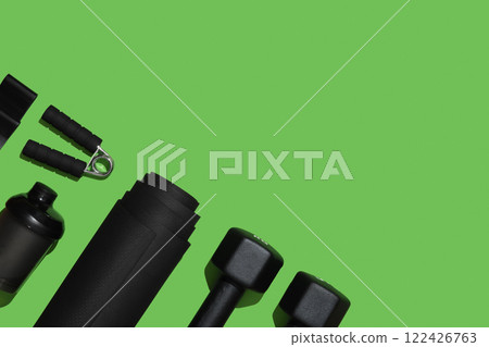 Black workout equipment for training at home on bright green background. Fitness, sport items, healthy lifestyle concept. Copyspace Black workout equipment for training at home on bright green background. Fitness, sport items, healthy lifestyle concept. Copyspace 122426763