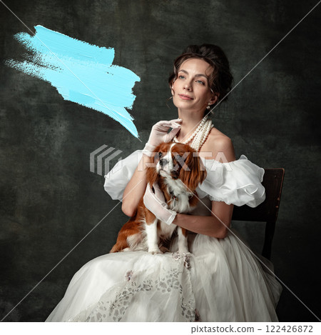 Vintage portrait of young elegant woman in image of medieval princess in renaissance style dress sitting with cute pet with blue abstract speech bubble. Vintage portrait of young elegant woman in image of medieval princess in renaissance style dress sitting with cute pet with blue abstract speech bubble. 122426872