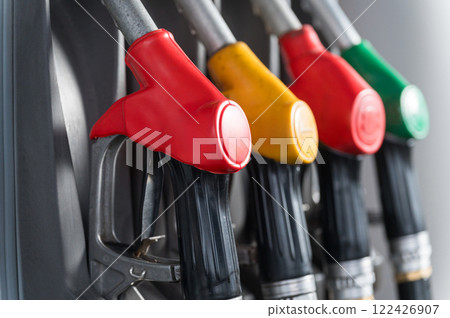 A close-up of colorful fuel pump nozzles at a modern gas station. 122426907