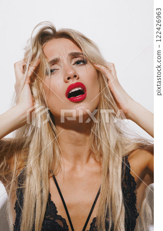 emotions and feelings concept - a breathtaking blonde woman in delicate lingerie, moaning in deep pleasure, trembling as she surrenders to passion, basking in bright studio light emotions and feelings concept - a breathtaking blonde woman in delicate lingerie, moaning in deep pleasure, trembling as she surrenders to passion, basking in bright studio light 122426963