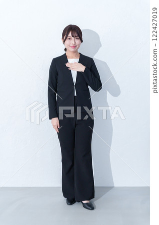 Full body of a young female businessman with hands on chest 122427019