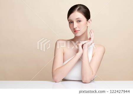 Beautiful young woman with clean fresh skin on beige background, Face care, Facial treatment, Cosmetology, beauty and spa, women portrait. 122427944