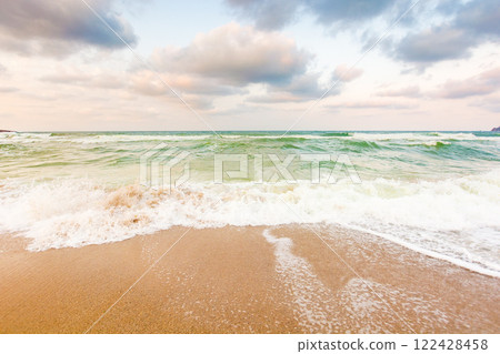 wave washing the sandy beach. travel destination. cloudy weather. scenery at the black sea in evening light. amazing climate of europe 122428458
