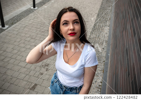 Young woman walking outdoors on a sunny day. Portrait of a cute woman outdoors. 122428482