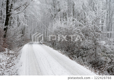 Snowy winter road with car. Dangerous car driving in the mountains in the winter. Concept for transportation, cars and travel. 122428788