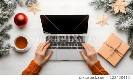 A freelancer working from a stylish apartment, typing on a laptop with a cup of tea and a notebook nearby 122430413