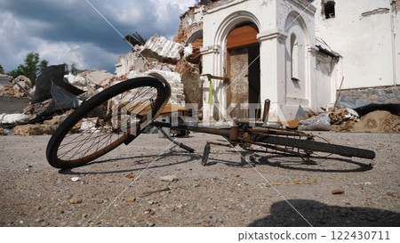 View to burned bike against the background of destroyed church at Kharkivska oblast. Ruined building after bomb attacks on ukrainian territory from russia army. russian invasion of Ukraine. Slow 122430711