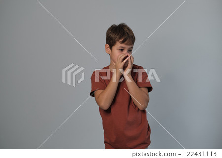 Boy in casual attire impersonates a wild creature, eyes popped and roaring. Reminds viewers of the uninhibited spirit of childhood and the universality of Youngster dramatizes a scare. 122431113