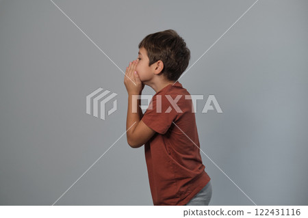 Boy in casual attire impersonates a wild creature, eyes popped and roaring. Reminds viewers of the uninhibited spirit of childhood and the universality of Youngster dramatizes a scare. 122431116